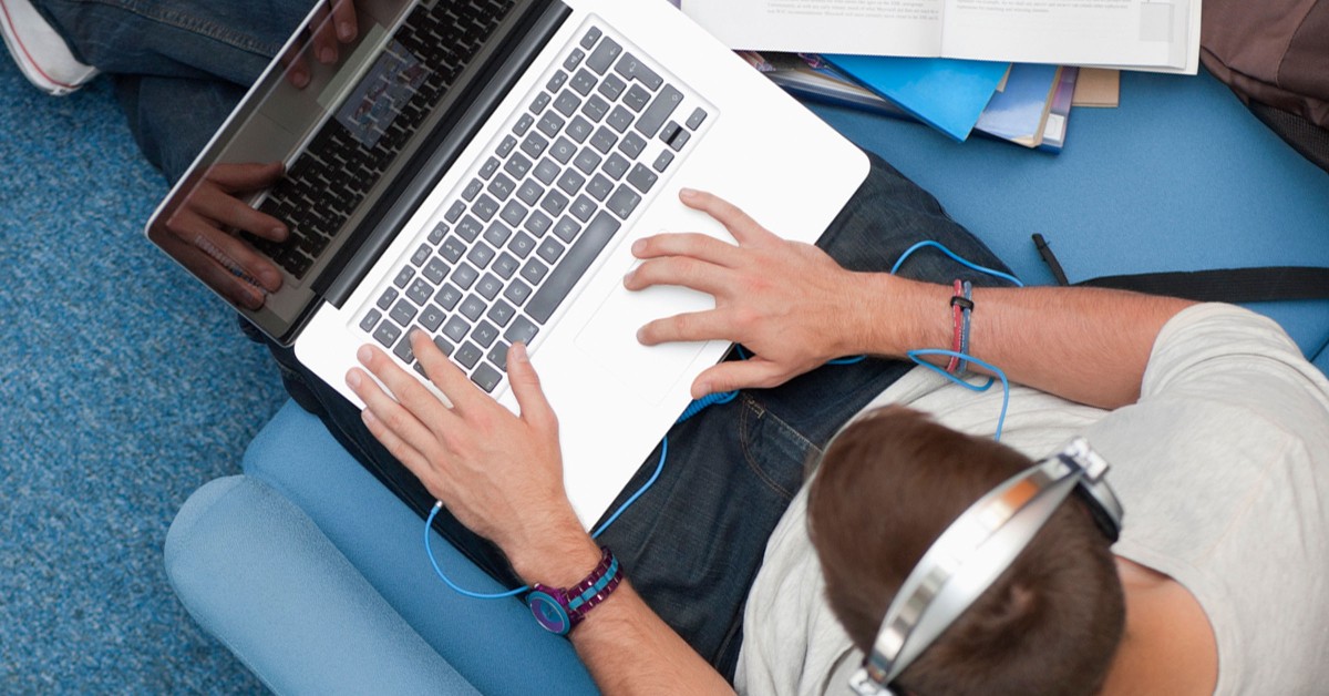 Overhead photo of a person wearing headphones and working on laptop